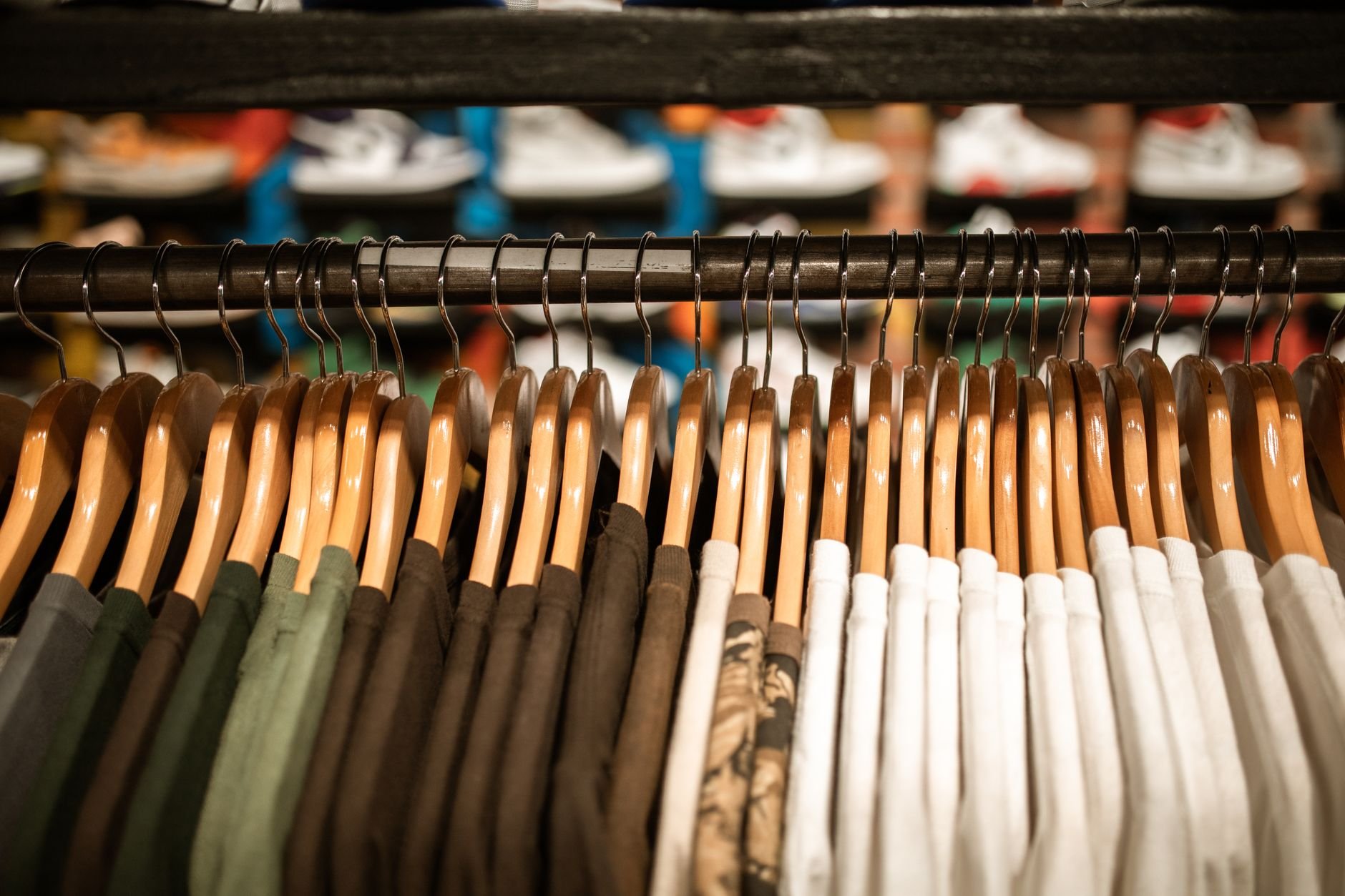 Row of colorful shirts on hangers in a clothing store, offering trendy fashion choices.